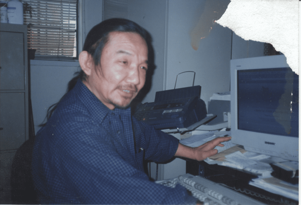 Kiyoshi Kuromiya sitting at desk